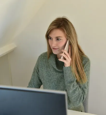 A woman listening closely during a phone call.